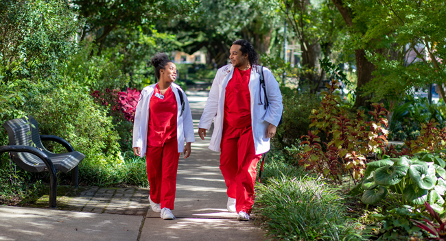 两名拉法耶特大学护理专业的学生在校园的橡树树冠下散步