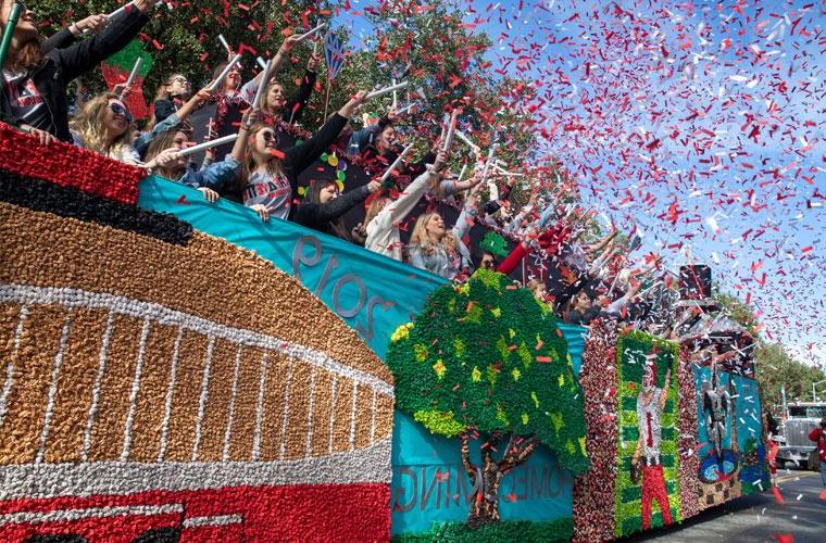 Red and white confetti around a float on St. Mary Boulevard for UL Lafayette Homecoming